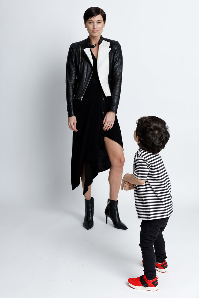 FORMERLY YAN Sleeveless V-Neck Midi Snap Dress With Asymmetrical Hem in Black Crepe Back Satin Convertible to Wear During Pregnancy. Layered Under A Black Leather Jacked and Worn with Booties 